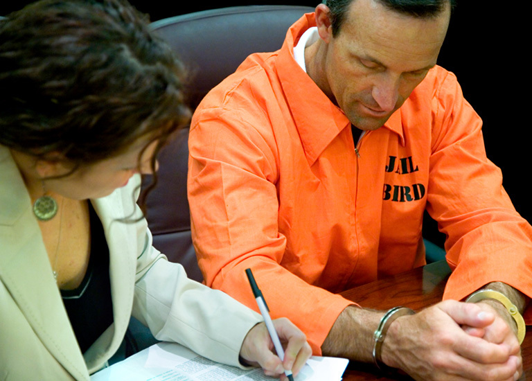 Female probation officer working with male inmate, filling out form