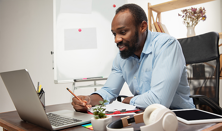 man excited at laptop ready tow rite something down