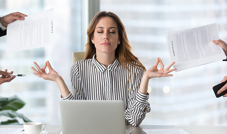 woman meditating in front of laptop