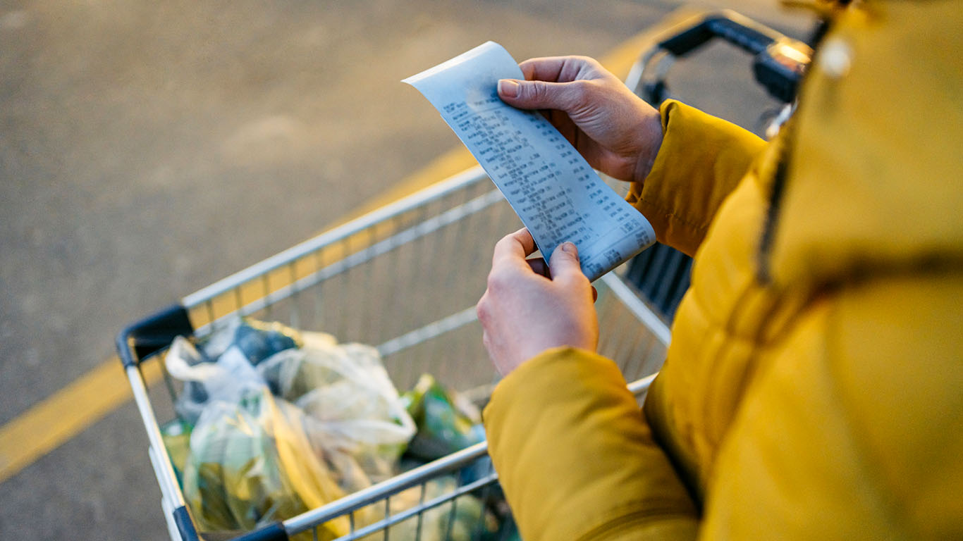 A woman reviewing a grocery receipt